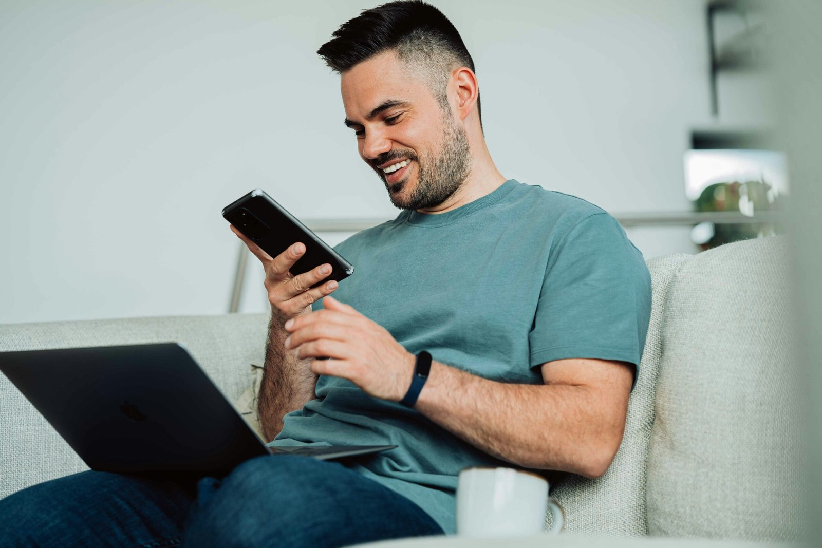 a man sitting on a couch and using a tablet